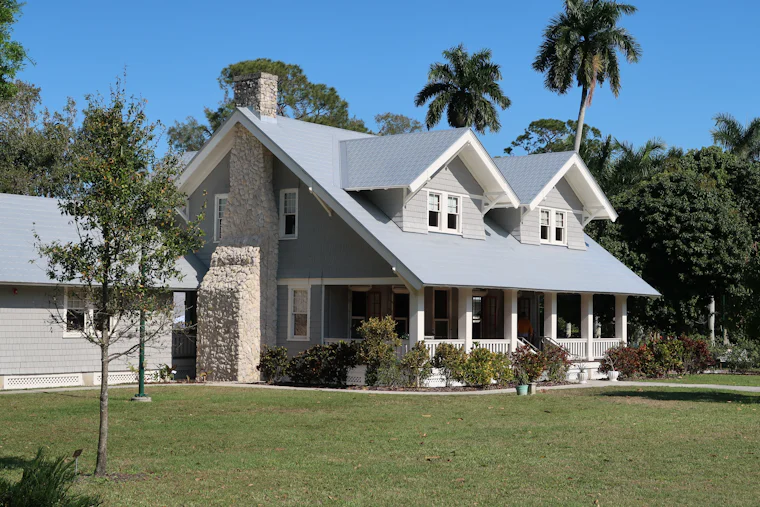 Casa de dos plantas rodeada de palmeras bajo cielo despejado