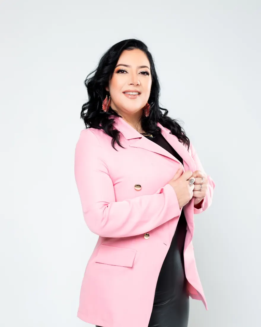 Kirsstien Gómez, asesora inmobiliaria, sonriendo con saco rosa